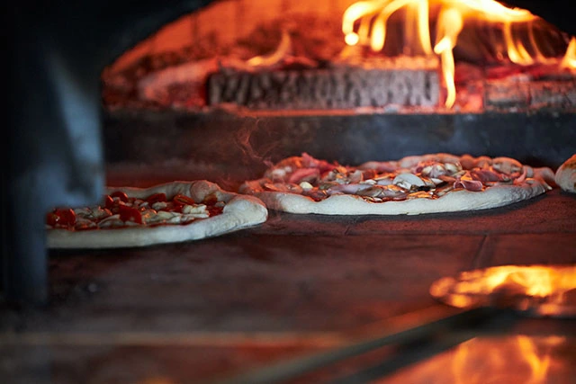 Photo of two pizzas in the oven